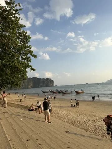 Ao Nang Beach with long-tail boats and limestone cliffs