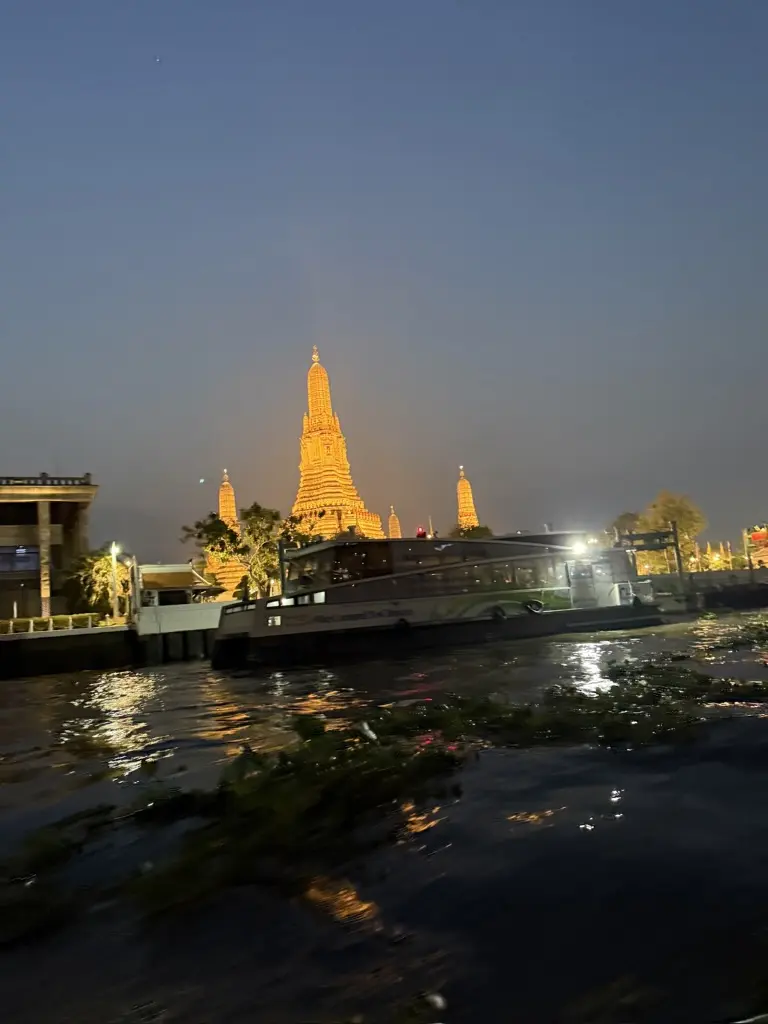Wat Arun illuminated beside the Chao Phraya River in Bangkok
